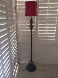 Black wrought iron floor lamp with red lampshade