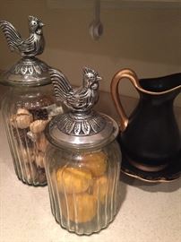 Kitchen canisters with pewter tops. Canisters come with lemons an potpouri Black gold pitcher with a rooster on front.  