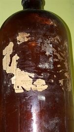 Antique brown glass jar with partial label 