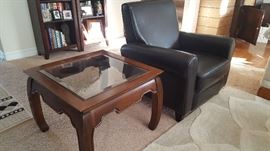 Asian motif end table and one of two leather-like reclining club chairs.