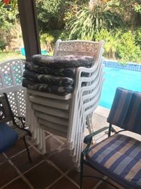 Stack of white plastic patio chairs