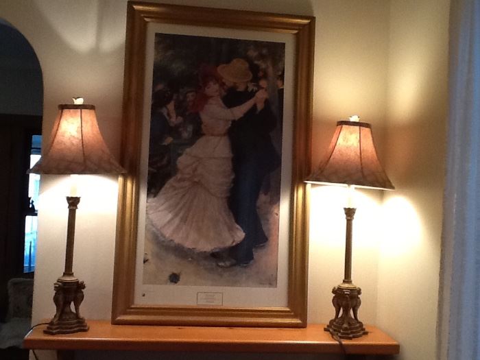 A set of two bronze table lamps with a framed reproduction of Renoir's painting.