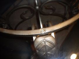 Glass top wrought iron table and four chairs, has black marble look cover