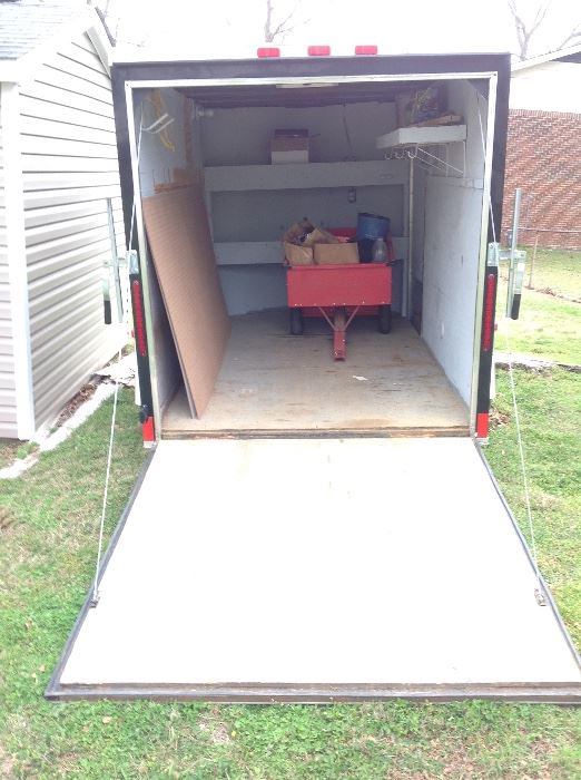 Rear open view of the Cargo Craft Trailer. Size 6' wide x 12' long x 6' high. This trailer features AC Electricity, DC  Interior Lights, overhead ventilation, built in storage binds, wall storage, and exterior side exit door. A Great Value! Must see!!! 