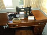 Vintage sewing machine in cabinet with all attachments
