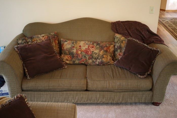 Sofa in sage green with deep purple (egg plant purple) throw pillows.