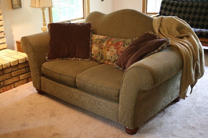 Love seat in sage green with deep purple (egg plant purple) throw pillows.