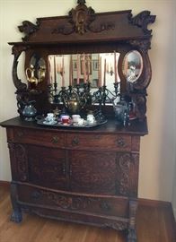 This is the best! Antique, tiger oak, ornately carved buffet with candle shelves and original mirrors. Circa 1900.