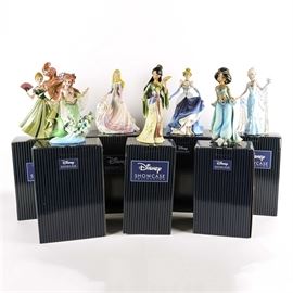 "Couture de Force" Collection of Disney Princess Figurines: A grouping of Disney Princess figurines from the Couture de Force line of the Disney Showcase Collection. Each of the six highly detailed pieces are crafted from stone resin and embellished with faux gems, encrusted crystals and opalescent paint. The collection includes Mulan, Aurora from Sleeping Beauty, Anna and Elsa from Frozen, Cinderella, Jasmine from Aladdin, and Ariel from The Little Mermaid. Each figurine is marked to the bottom and presented in its original box.