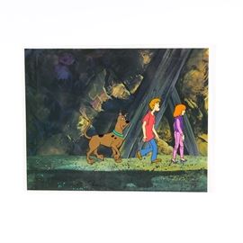 Original "The 13 Ghosts of Scooby-Do" (1985) Animation Cel: An original hand painted animation cel from the show The 13 Ghosts of Scooby-Do (1985). It depicts Scooby, Shaggy, and Dafne walking forward in a line, with animation and shot numbers hand written on the lower margin. The clear plastic cel is set against a printed cave background. Includes a Classic Moments Certificate of Authenticity on the reverse.