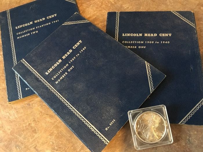 Penny collector books and a couple silver dollars