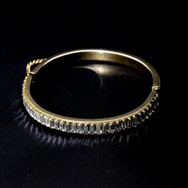 Rhinestone Bangle Bracelet: A bangle bracelet. This selection includes a bracelet adorned with square-shaped rhinestones. It also showcases a snap closure affixed with a chain. It bears no visible maker’s marks.