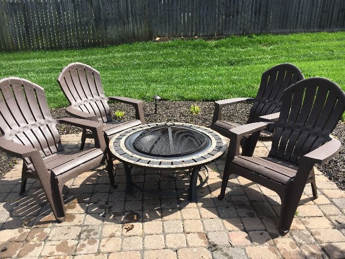 Fire pit and four plastic Adirondack-style chairs. (Brought into garage for sale) 