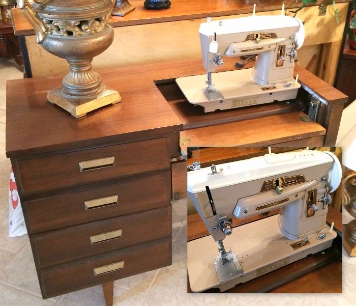 Vintage metal Singer sewing machine in 3 drawer mid century wood cabinet. Working machine folds into a desk style furniture arrangement when not in use.