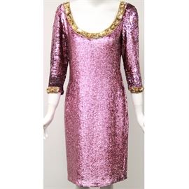 Vintage Naeem Khan Pink Sequin Cocktail Dress: A vintage Naeem Khan pink sequin cocktail dress. This cocktail dress features an exaggerated scoop neck with long sleeves with gold tone trim around the neck and the sleeve openings with a closed back and a zipper enclosure in a pink color throughout. The tag does read, “Naeem Khan Riazee”.
