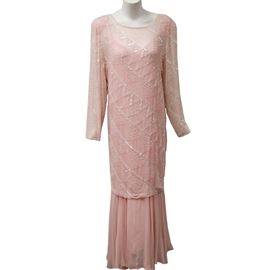 1980s Oleg Cassini Pink Silk Beaded Gown: A circa 1980s beaded silk gown. This selection features a pastel pink silk gown with a sheer, beaded overlay. It includes a zipper closure and is labeled by Oleg Cassini. Made in China.