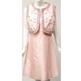 Vintage Dynasty Raw Silk Dress and Beaded Vest: A vintage Dynasty raw silk dress and beaded vest. The sleeveless A-line dress features an empire waist and back metal zipper. The dress includes a matching bolero style vest with colored bead and glass embellishments and trim. Both pieces have a stitched in designer label, “Dynasty Dry Clean Only Made In The British Crown Colony of Hong Kong.”