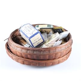 Vintage Sewing Assortment: An assortment of vintage sewing supplies. Included are buttons, spools of thread and knitting knobby’s as well as a pair of wicker baskets.