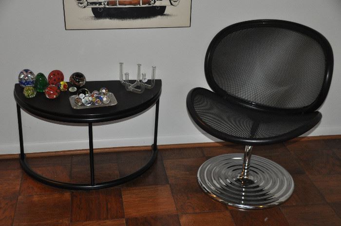 MCM black leather and mesh with chrome swivel base chair by Vecta Contract shown with a black contemporary semi circle low table 