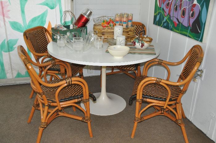 Vintage tulip style 48" white formica top dining table with metal base. Shown with 4 wicker/bamboo style dining chairs