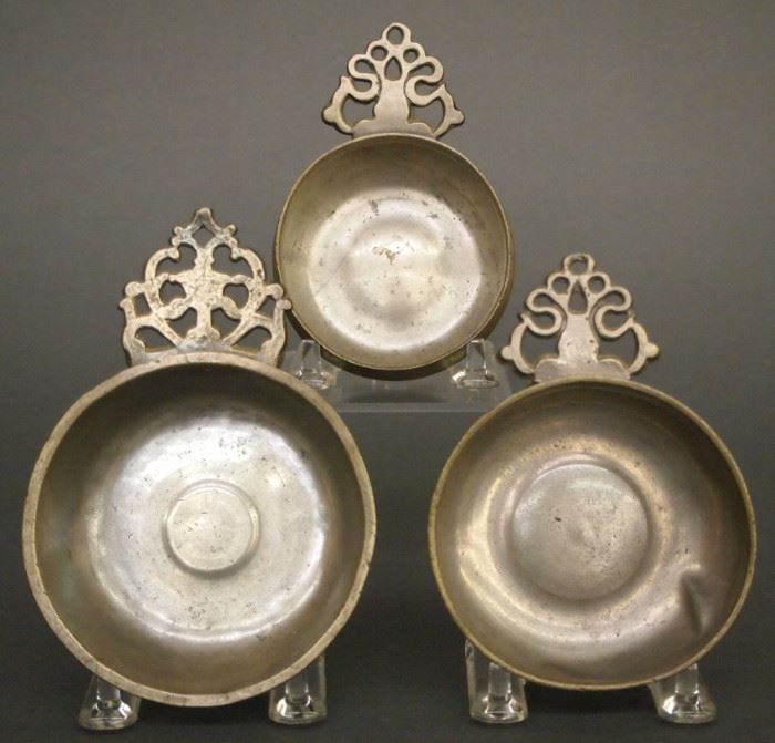 Three early 19th century Pewter porringers.  All having "Old English" form pierced handles.  Some wear, slight denting.  Up to 4 3/4" long overall. ESTIMATE $100-150