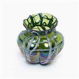 Kralik Veined Favrile Glass Vessel: A favrile glass vessel created by Kralik Glass. This piece features a melon shaped body with veined silver tone overlay and a palette of green, blue, purple, and yellow throughout. There are no visible makers markings on this vessel.
