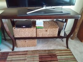 Wonderful console table. Dark wood finish with canned bottom shelf