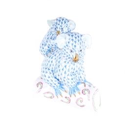 Herend Hungary Porcelain Koala Figurine: A Herend porcelain figurine. The porcelain figurine deicts a mama koala bear with baby koala on her back in blue fish scale pattern with a white tree stump shaped base with pink and green accents. Figurines has a maker’s mark and signature on the bottom.