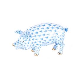 Herend Hungary Pig Porcelain Figurine: A Herend Hungarian pig porcelain figurine. This hand painted porcelain pig figurine features a blue signature fishnet design with 24K gold accents. This figurine depicts a standing pig which appears open mouthed. The fishnet design was first inspired by a Herend painter in 1858, who was influenced by China fish scale style patterns. Herend is a Hungarian porcelain manufacturing company, specializing in hand painted and gilded luxury hard paste porcelain. This figurine includes a blue Herend Hungary porcelain mark on the bottom.