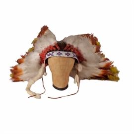 Vintage Native American Style War Bonnet Headdress: A vintage Native American-style Plains type war bonnet headdress. It features a leather base with a blue, red, yellow and white beaded pattern along the headband and holds a series of feathers to it. The headdress is unmarked.