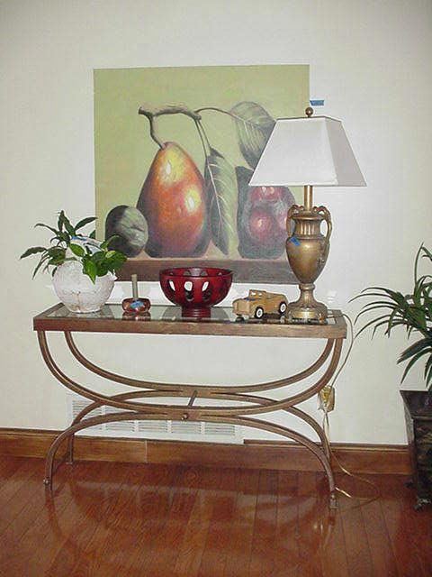 Metal and glass table with stretched canvas artwork above