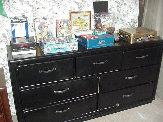 Dresser painted black; selection of games including many variationsof Trivial Pursuit, puzzles, and more