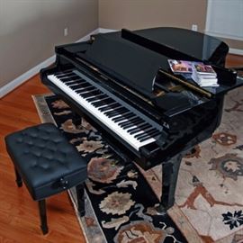 Yamaha Grand Piano with Disklavier: A Yamaha G3E grand piano with Music Systems Research model PD S128 Disklavier. Features include a polished ebony case, brass tone hardware, collapsible sheet music stand, three pedals, and three square tapered legs with casters. A matching black vinyl tufted adjustable piano bench with tapered legs and square feet is included.