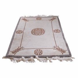 Hand Tufted and Carved East Asian Inspired Area Rug: A hand tufted and carved East Asian inspired area rug. This rug features a cream field with large geometric patterns in a burnt umber. It has been carved along the design lines for a textural appearance and is finished with a natural cotton warp fringe at either end. Unmarked.