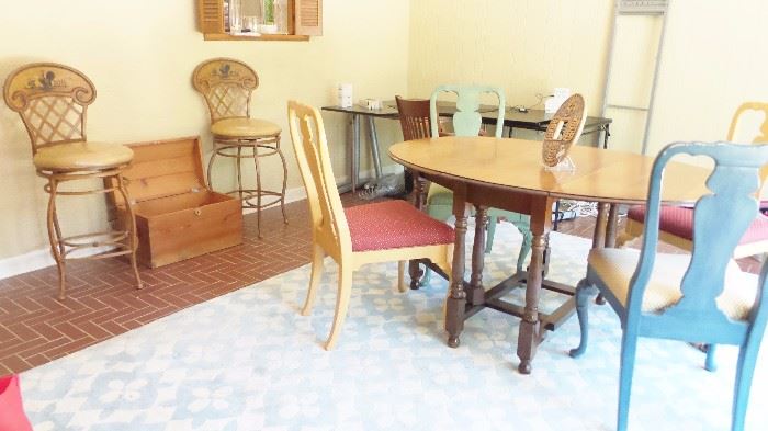 Drop leaf dining table.  8 painted dining room chairs in color sets of 2.  Large blue white area rug, 3 Rooster, iron bar chairs, wood chest.  Ikea cornerdesk