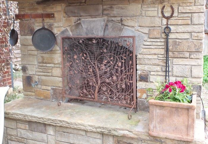 Outdoor cooking fireplace with iron tools, pans, pots, fireplace screen