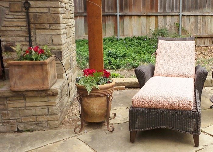 Wicker style chaise lounge.  Pots, planters, plants, Iron work