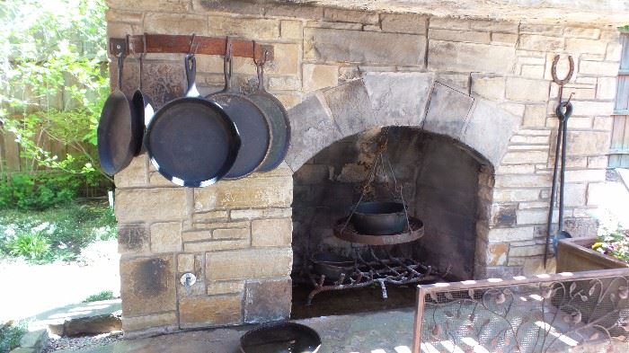 Outdoor Kitchen with cast iron (Wagern's, Lodge) pots and pans and cooking vessels, tools and utensils. Fireplace screen