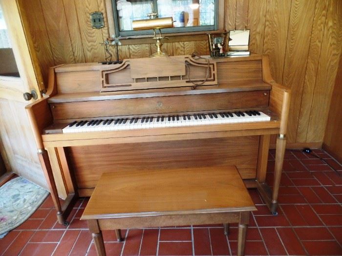 Smaller piano with bench, has wheels for easy placement