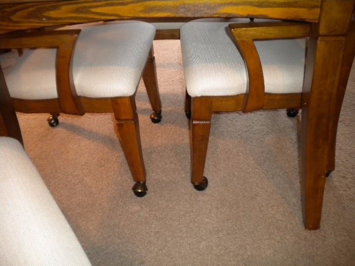 Solid wood game table interchangeable top four armed chairs on castors.