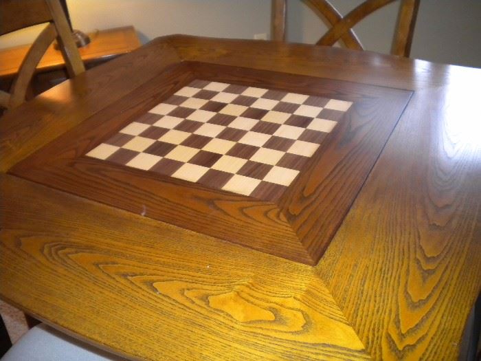 Solid wood game table interchangeable top four armed chairs on castors.