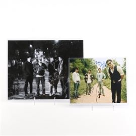 Pair of Mumford and Sons Autographed Photos: A pair of photographs signed by members of the band Mumford and Sons. This pair features a large black and white image signed in silver ink by the band members. Also included is a color photograph signed in blue and black ink. Includes a certificate of authenticity from The Friendly Stranger.