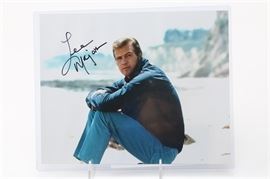 TV Guide and 8x10 Signed by "Six Million Dollar Man" Lee Majors: A TV Guide and 8" x10" signed by actor Lee Majors, known for his television roles in The Six Million Dollar Man, The Big Valley and more. The TV Guide features an illustration of Majors in character as the “Bionic Man”; the magazine is signed and authenticated. The 8″ × 10″ has not been verified as an authentic signature.