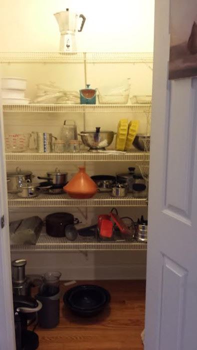 pantry stocked with pots, pans, serving tools, bakeware, blender, juicer, etc.