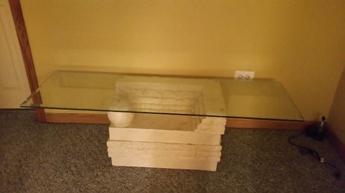 Stone base, glass top coffee table.