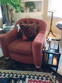 Kravet upholstered chair; plant stand in background; cantebury next to chair; rug in foreground