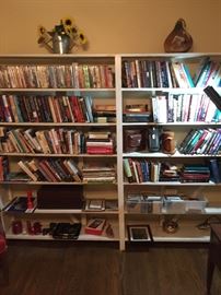 Double bookshelf containing many books, dvds, and cd's