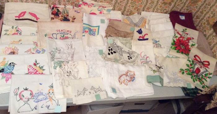 Vintage linens including embroidered dish towels, pillow cases, damask tablecloths & more