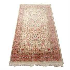 Machine Woven Karastan "Kirman" Area Rug: A machine woven Karastan “Kirman” area rug. This wool “Kirman” rug was made in the U.S. and is pattern 708.This beautiful rug has an ivory field with multi-colored floral designs in pinks, blues, and browns with two of the sides finished with ivory colored fringe.
