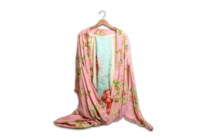 Japanese Silk Kimono from the 1950s: A vintage Japanese silk kimono from the 1950’s. The silk dress has a printed floral and lantern design on a pink background. The kimono has a large sleeve and spode with red lining. A blue silk obi with red embodied circles accompanies the kimono.